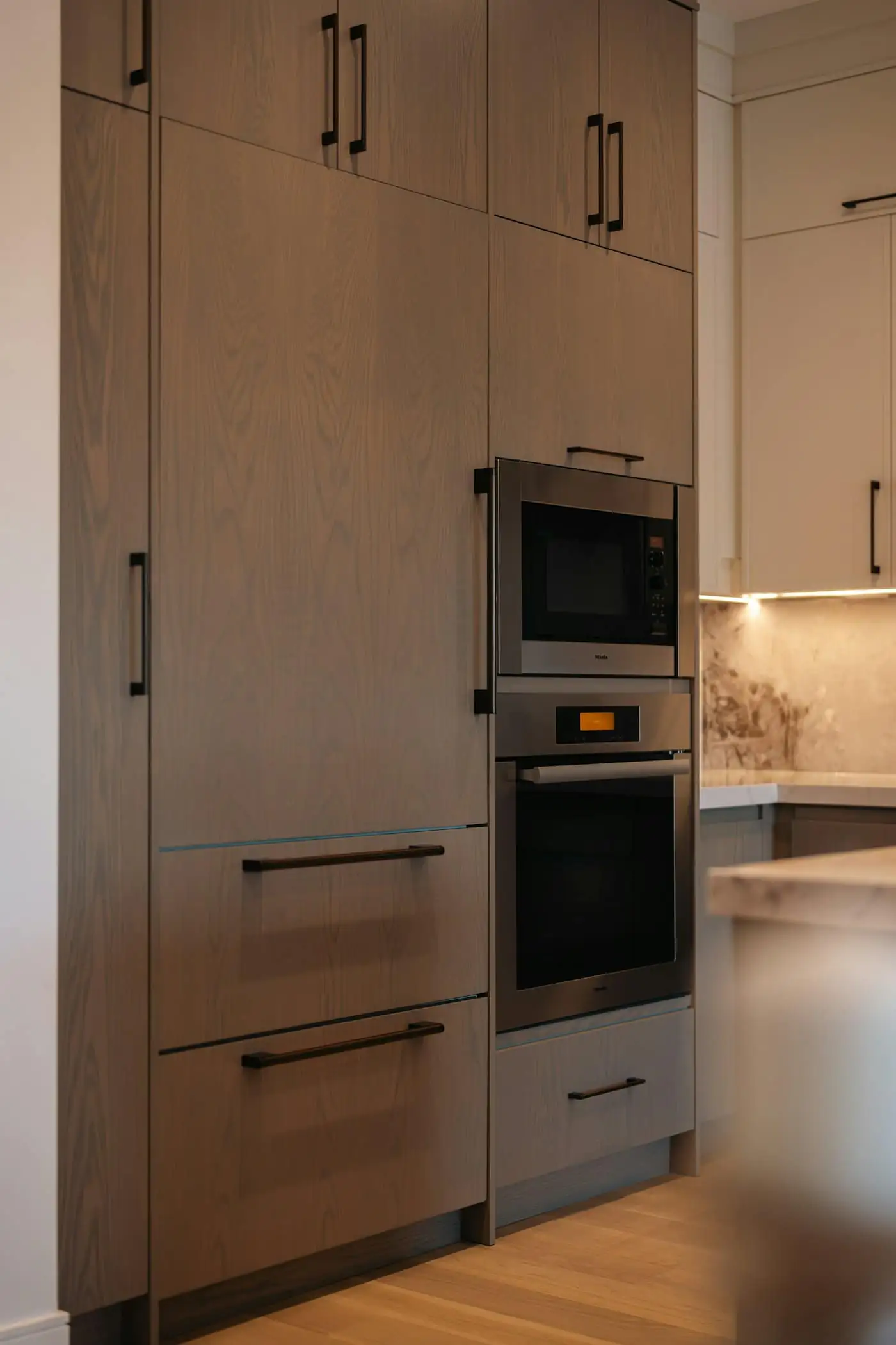 Floor-to-ceiling kitchen cabinets with built-in fridge and oven