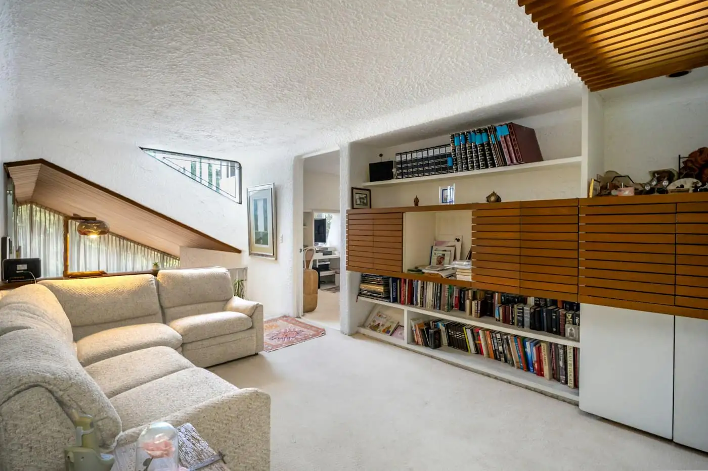 Living room with built-in shelving and timber louvred windows